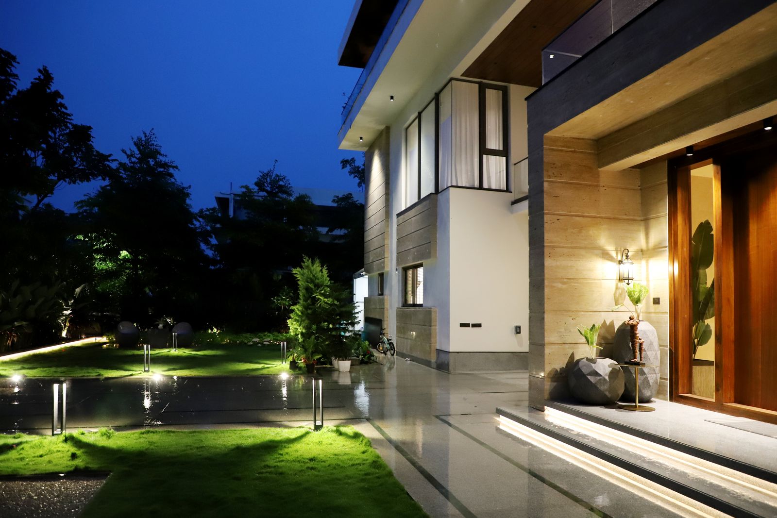 Volusia County home at night with evenly lit entry and lawn path lights, no glare
